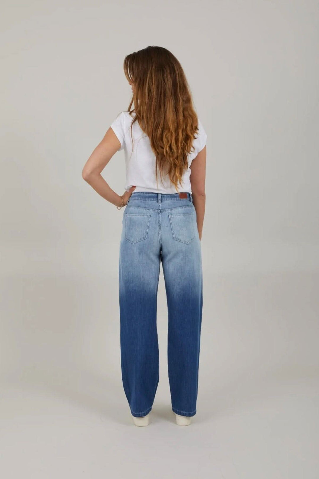 Femme de dos portant des jeans à jambes larges avec dégradé, style décontracté et moderne.