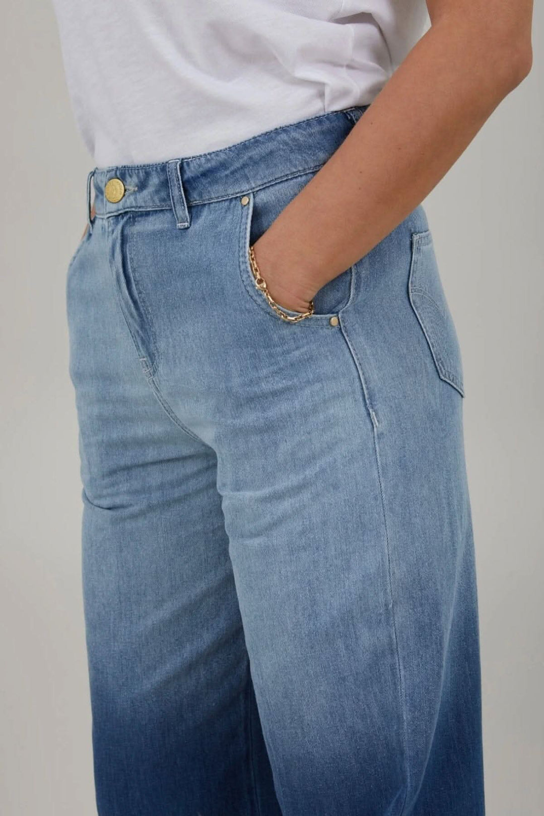 Jean à jambes larges taille haute avec poches avant, porté avec un t-shirt blanc.