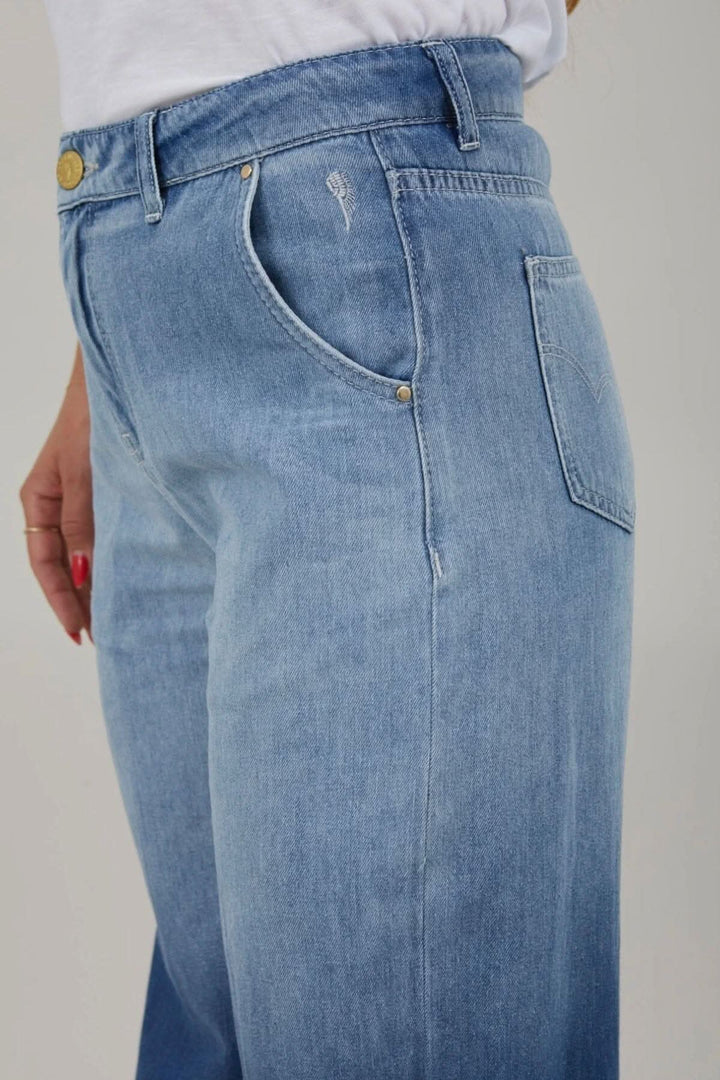 Jean à jambes larges taille haute, poches avant, denim bleu, coupe Petra, détails élégants.