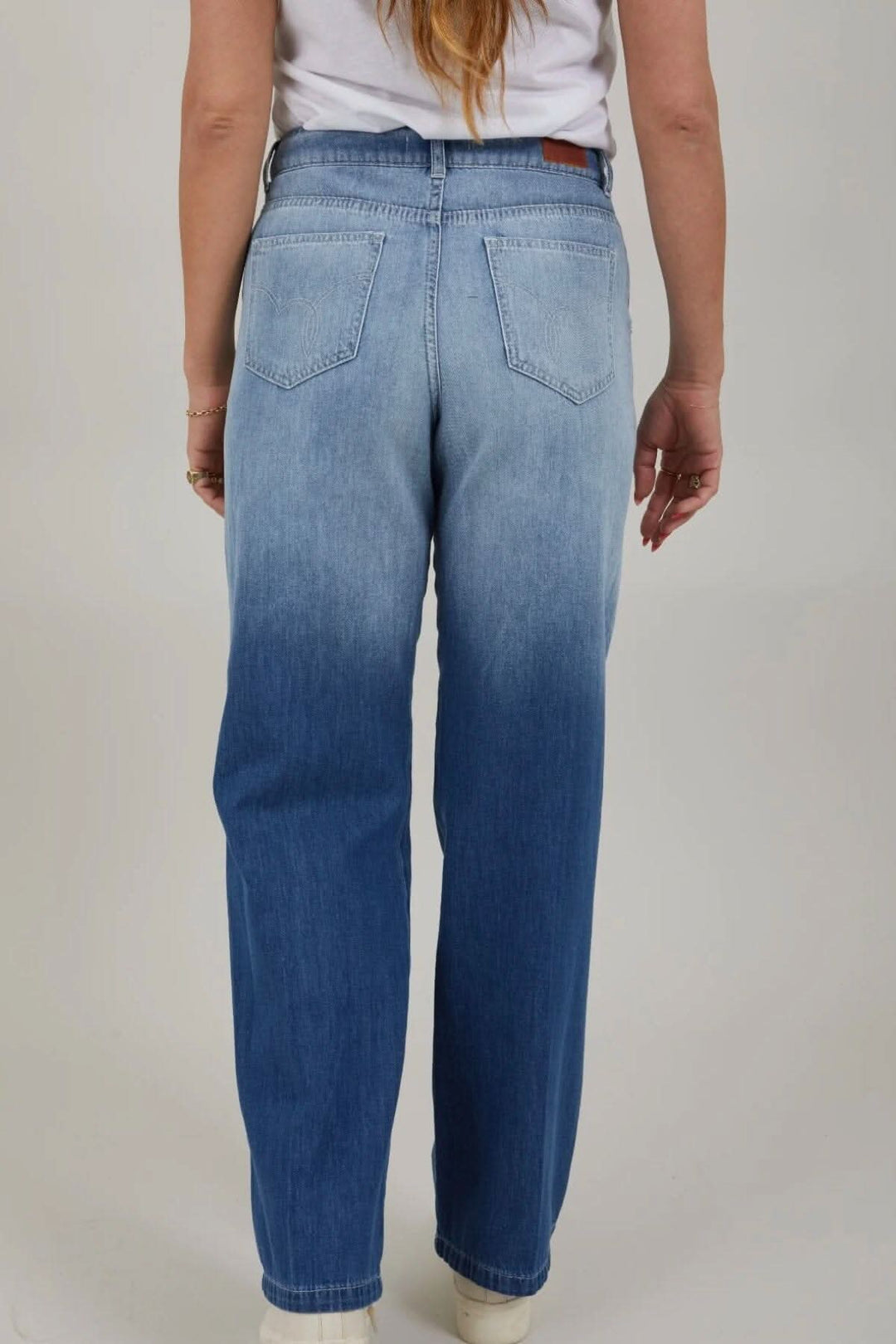 Jean à jambes larges en dégradé de bleu, vu de dos, avec poches arrière et taille haute.