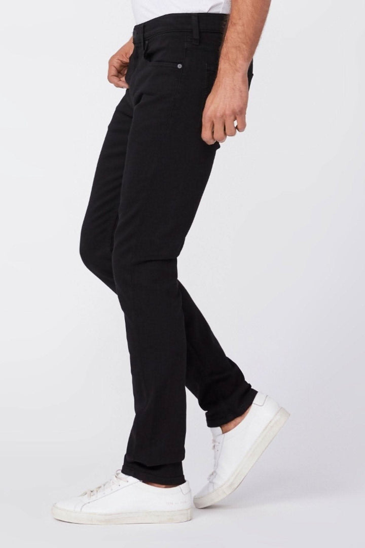 Homme portant un jean noir slim Lennox, coupe ajustée, avec des baskets blanches.
