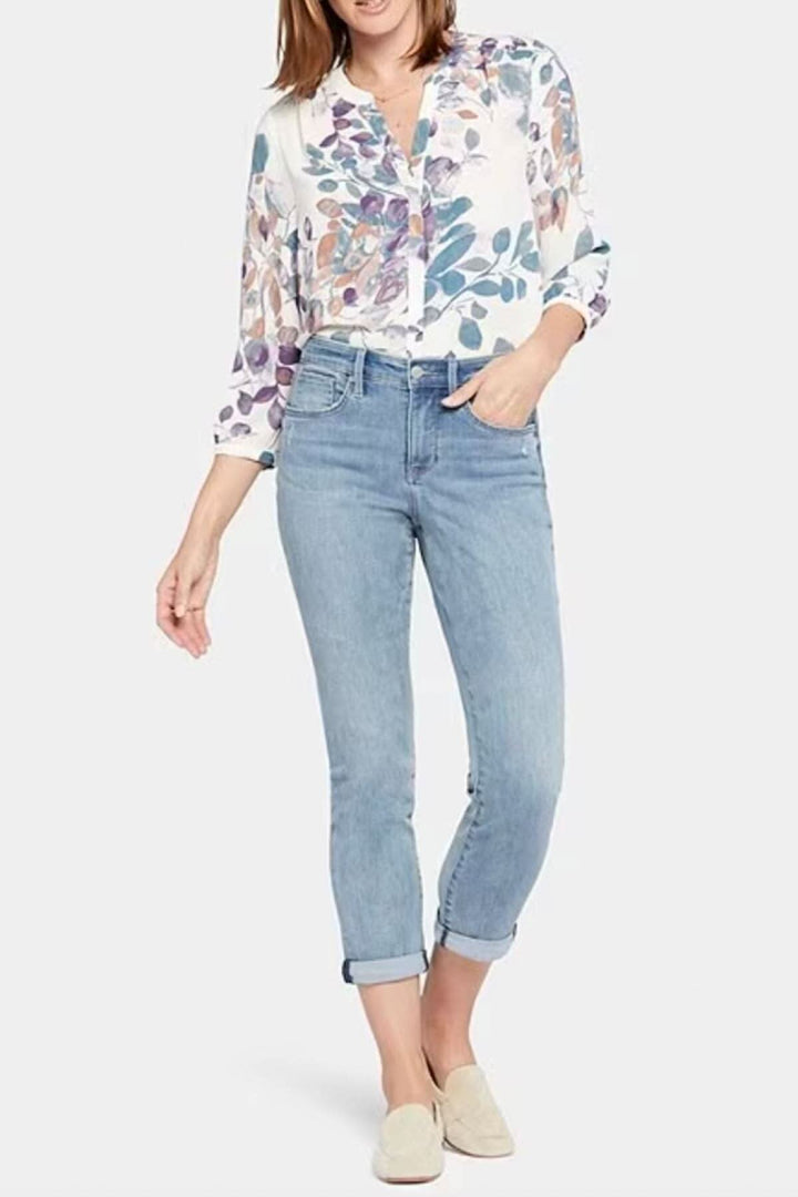 Femme portant un jean boyfriend slim à taille haute Margot, avec une chemise à fleurs et des chaussures beige.