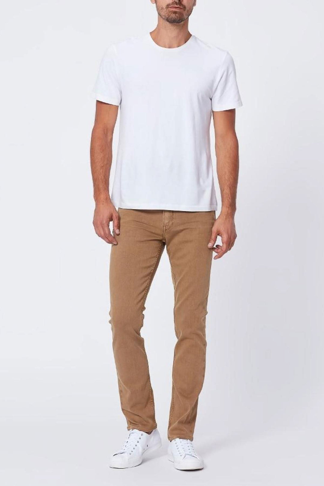 Homme portant un t-shirt blanc et un jean couleur châtaignier, look décontracté et élégant.