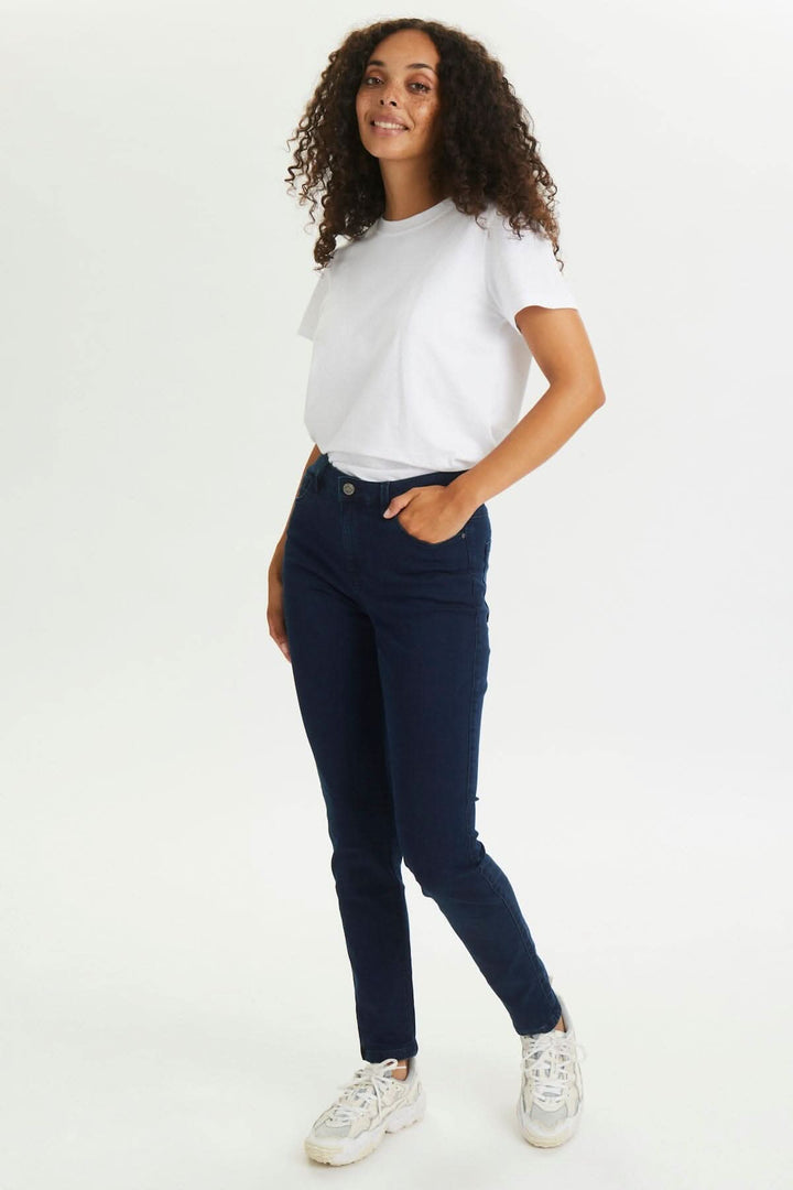 Jean Vicky en denim foncé porté par une femme avec cheveux bouclés, style décontracté.