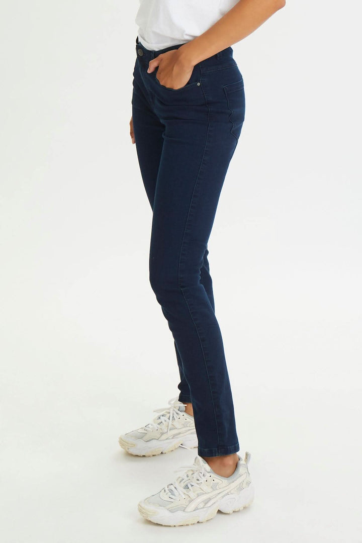 Jean Vicky féminin, coupe étroite en coton, polyester et élasthanne, porté avec des baskets blanches.