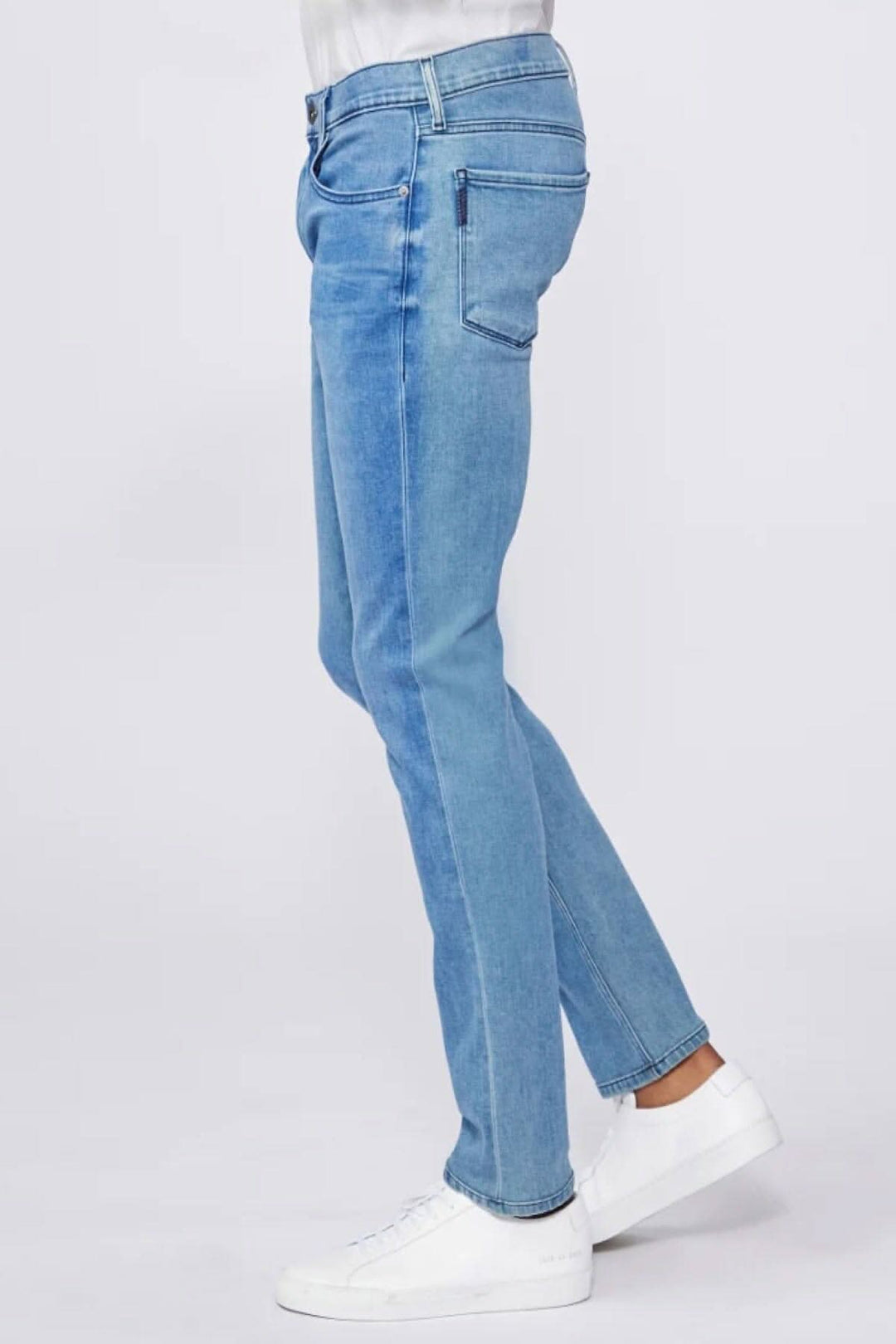 Jean Paige Lennox Boxter en délavé moyen, coupe ajustée, porté avec des baskets blanches.