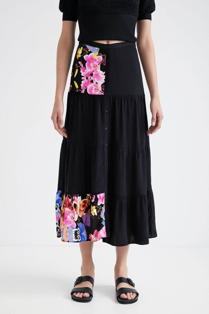 Jupe longue noire à taille haute avec imprimés floraux colorés, style bohème chic Christian Lacroix.