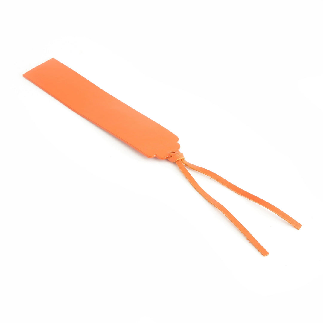 Handmade orange leather bookmark with tassels for elegant page marking.
