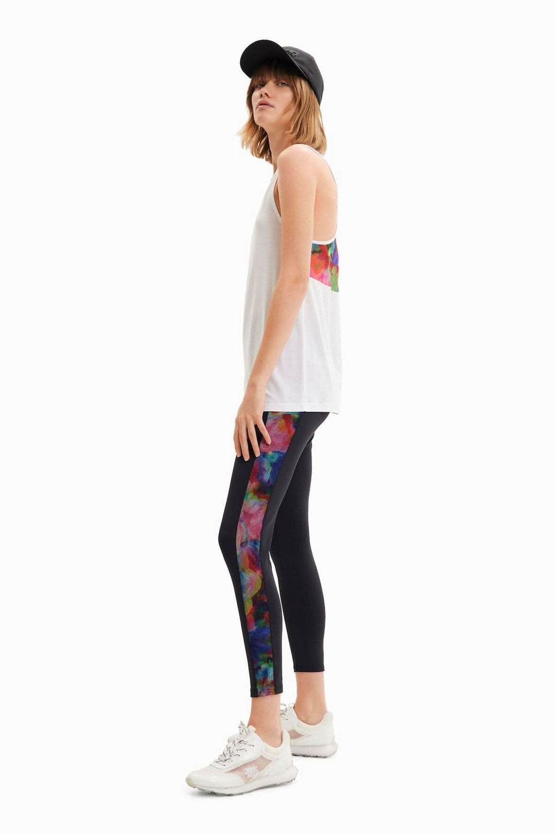 Legging sport ajusté à taille haute avec impression florale et bande latérale en filet, porté par un modèle.