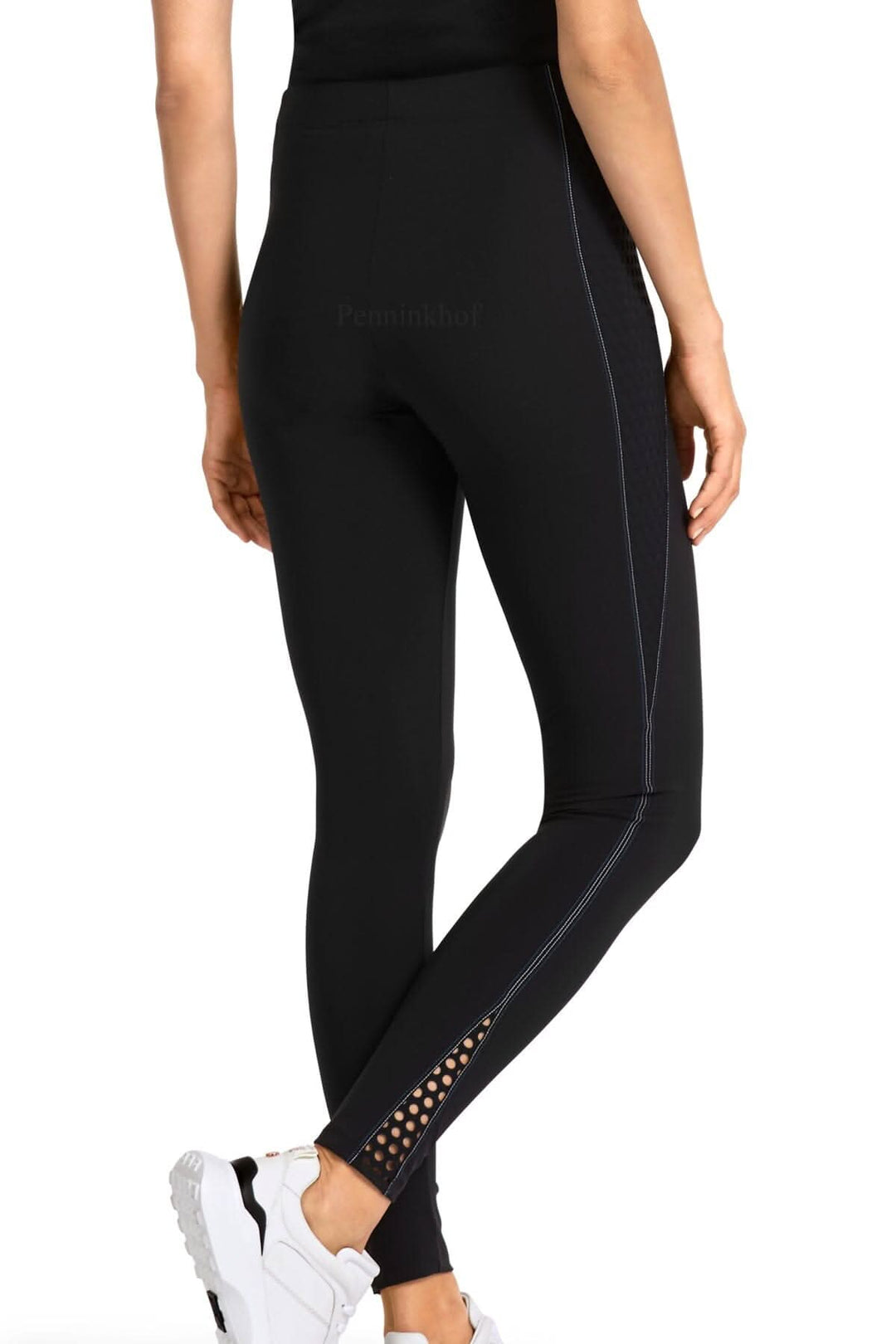 Legging de sport noir Marc Cain avec détails perforés et couture blanche, coupe ajustée.