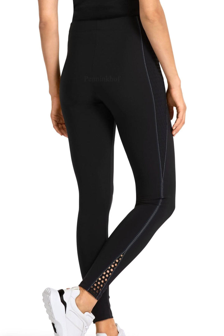 Legging de sport noir Marc Cain avec détails perforés et couture blanche, coupe ajustée.