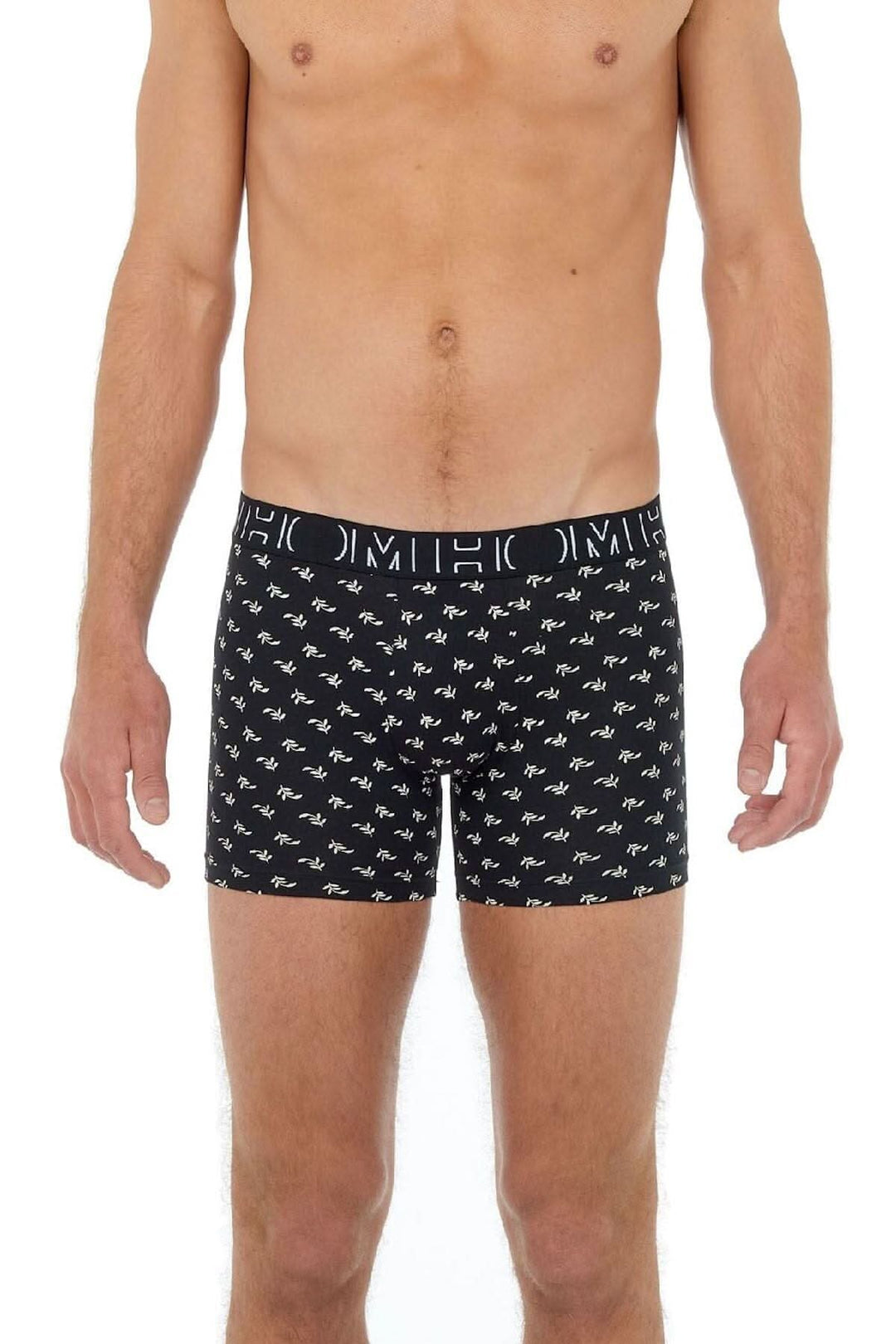 Homme portant des boxers noirs avec motifs végétaux, en coton élasthanne, ensemble élégant et confortable.