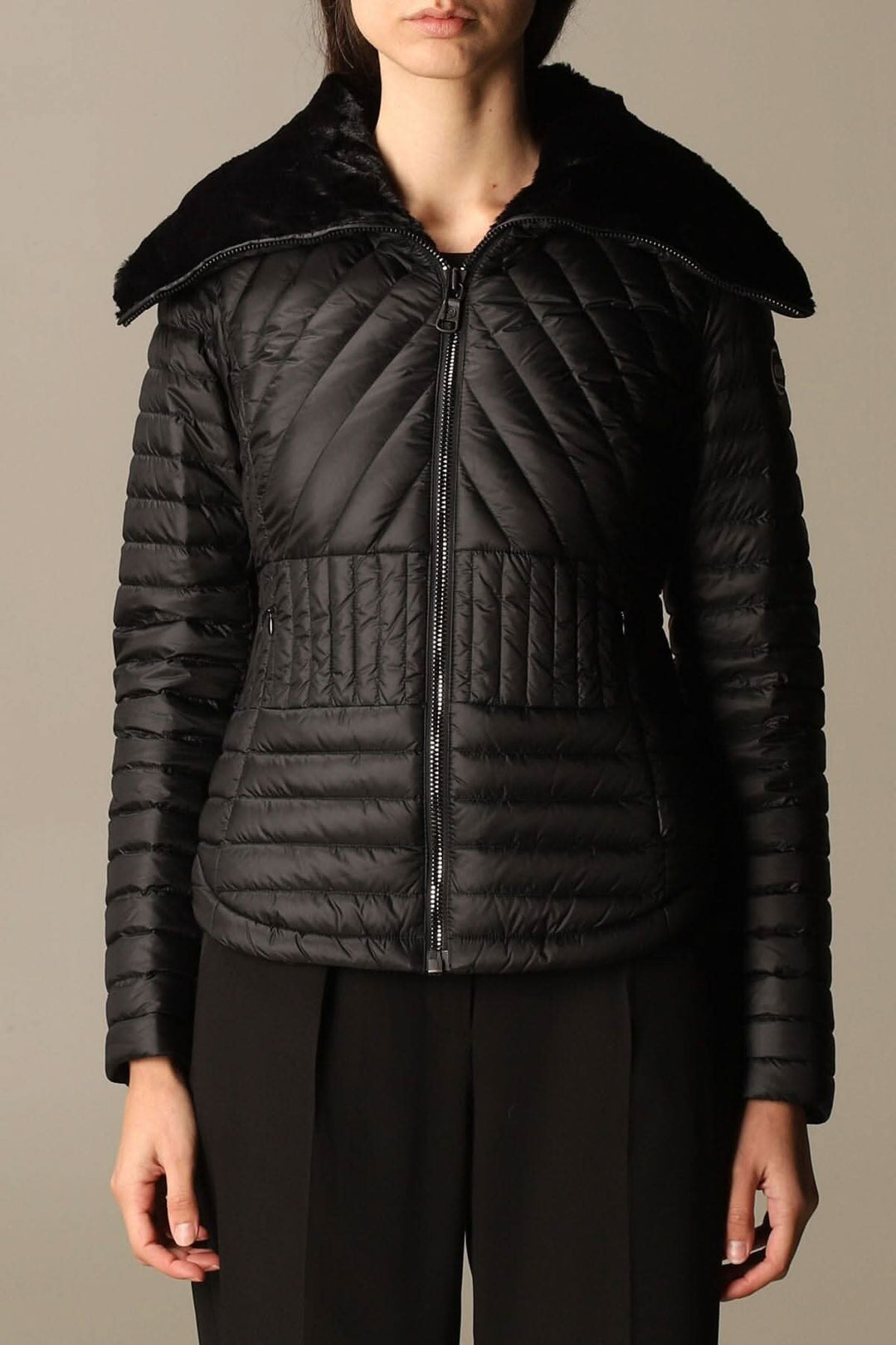 Veste matelassée noire avec col montant en fausse fourrure, fermeture zippée, coupe féminine.