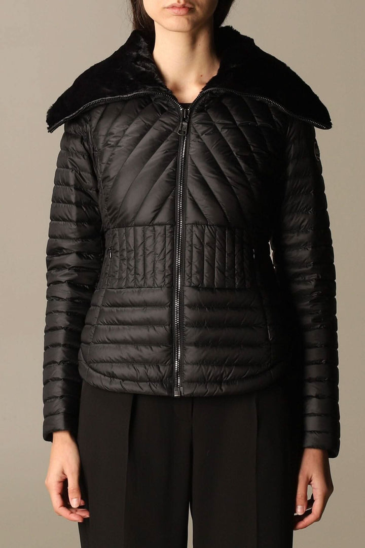 Veste matelassée noire avec col montant en fausse fourrure, fermeture zippée, coupe féminine.