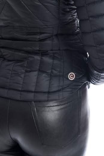 Détail du manteau noir matelassé COLMAR avec logo, porté avec un pantalon en cuir.