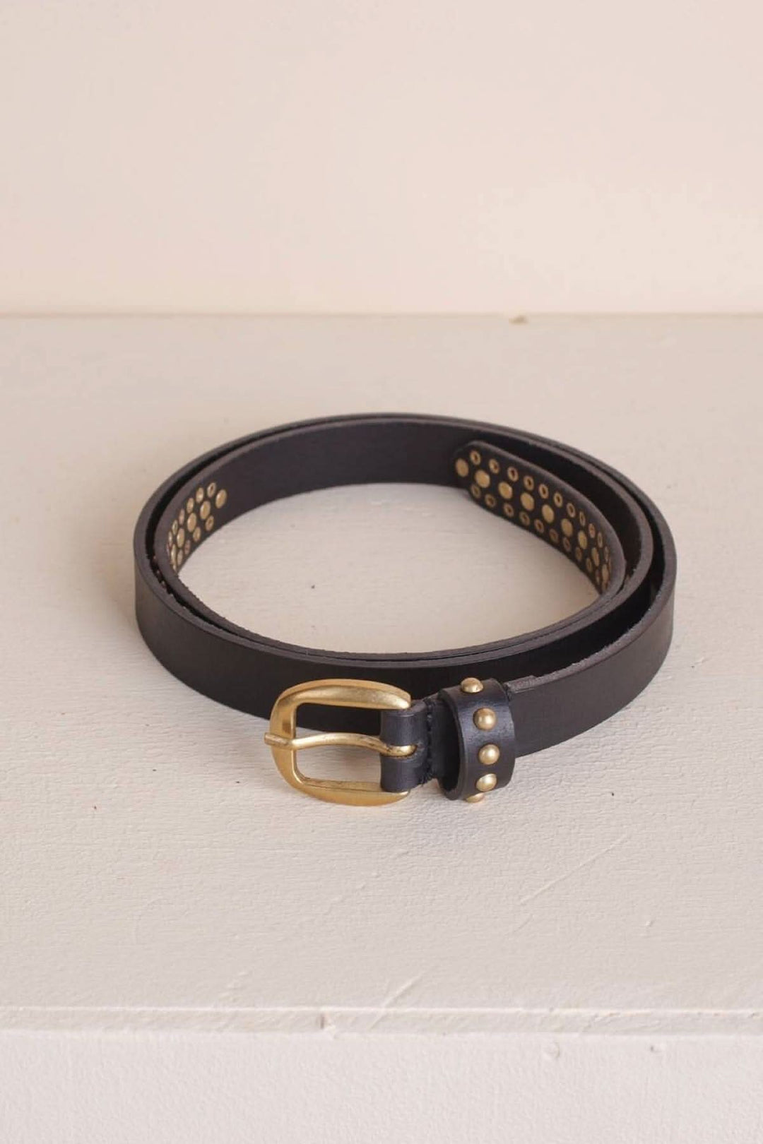 Mini ceinture à clous en cuir noir avec boucle dorée et clous métalliques.