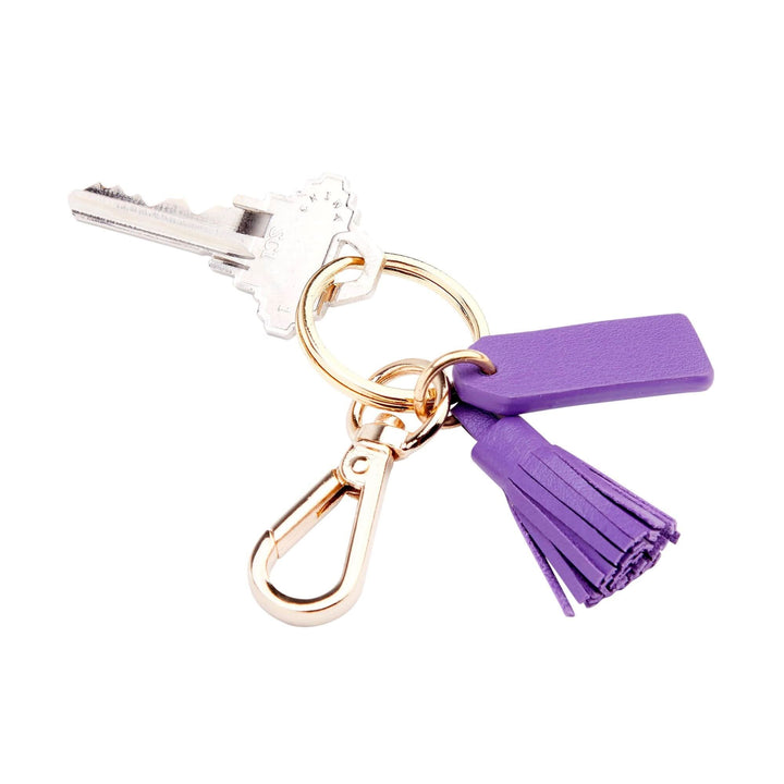 Mini tassel key fob with goldtone hardware, purple tassel, and key attached, stylish for organizing keys.