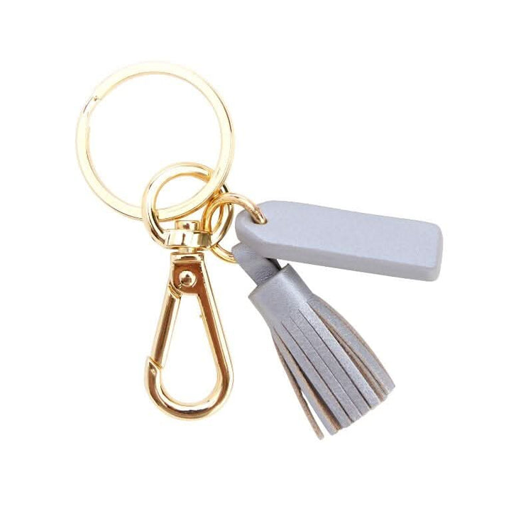 Mini tassel key fob with goldtone hardware and gray tassel, perfect for organizing keys and enhancing bag style.