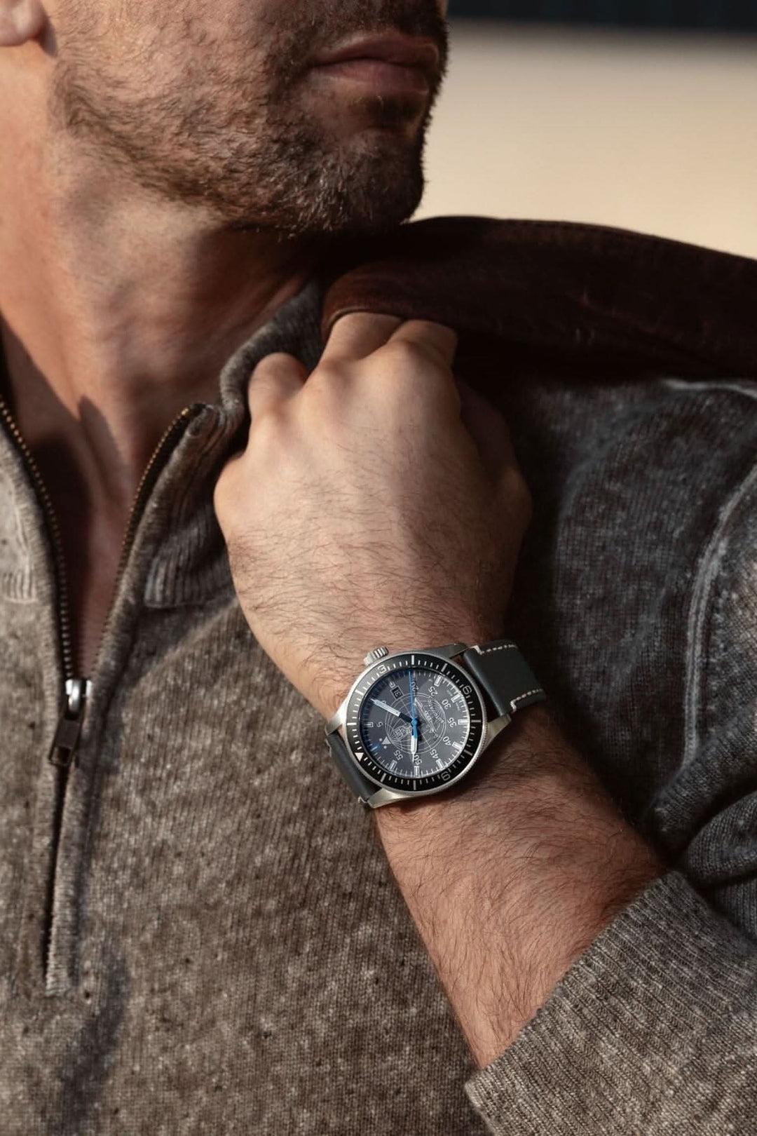 Homme portant la montre Constellation 9602 avec cadran gris et bracelet en cuir dans un environnement naturel.