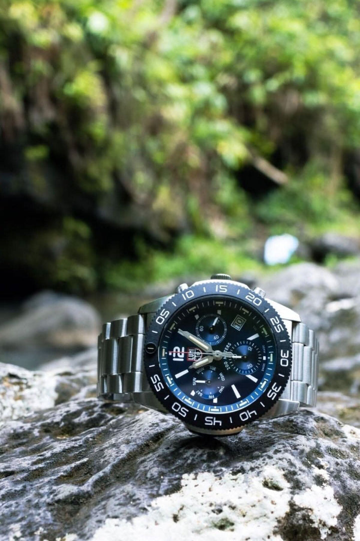 Montre Luminox Pacific Diver 3144 en acier inoxydable sur un rocher au bord de l'eau, parfaite pour les explorateurs.