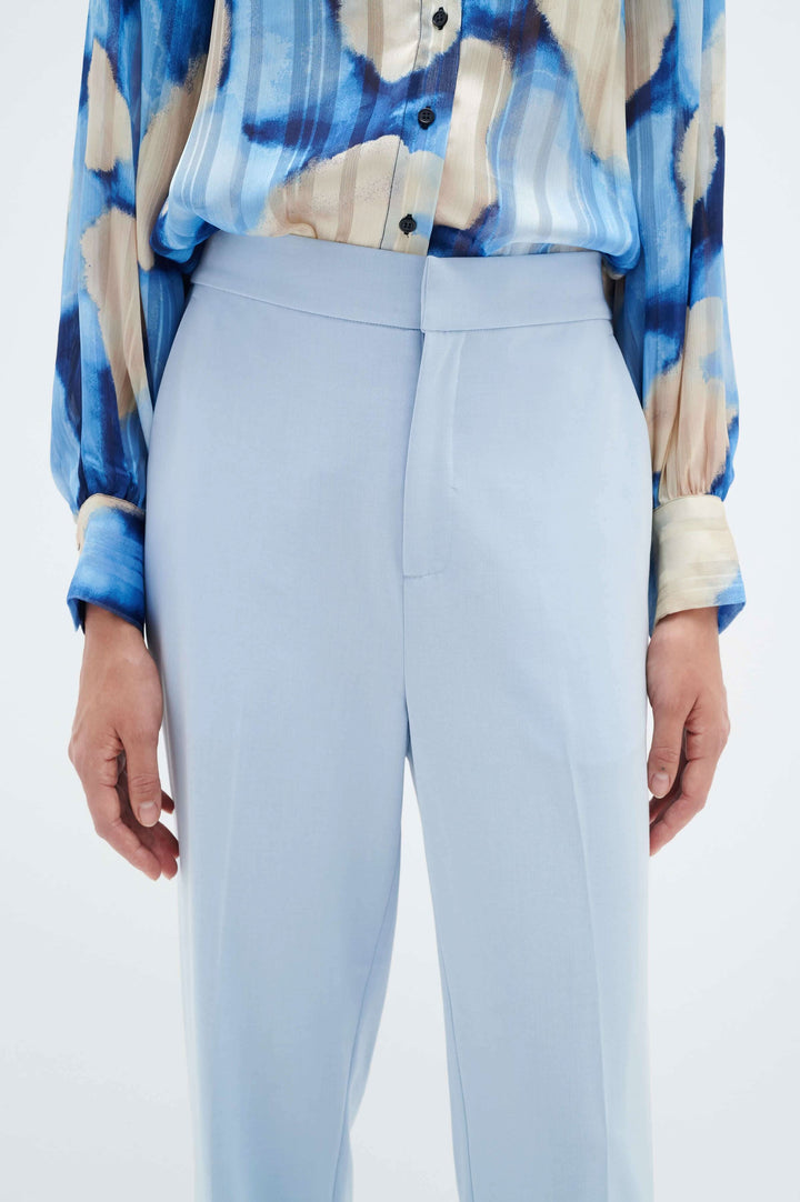 Pantalon à revers Naxa, confortable avec jambe fuseau et taille élastique, porté avec une chemise colorée.