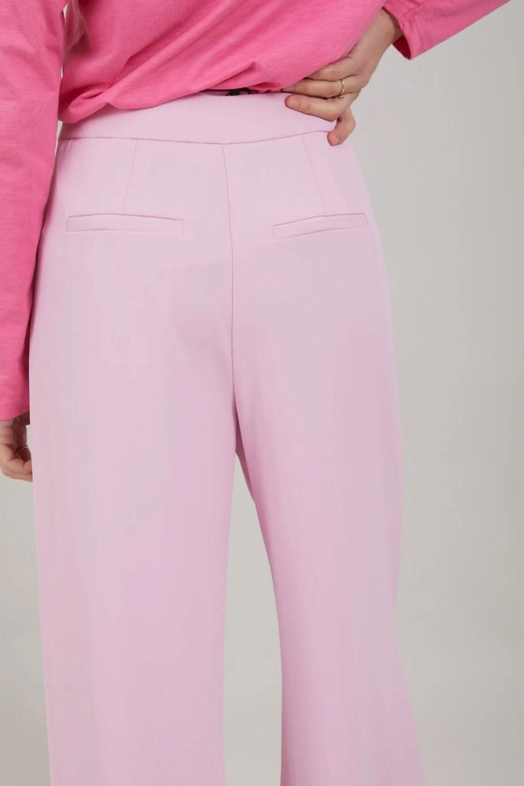 Vue arrière du pantalon Alba en rose, mettant en évidence les poches arrière et la coupe large.