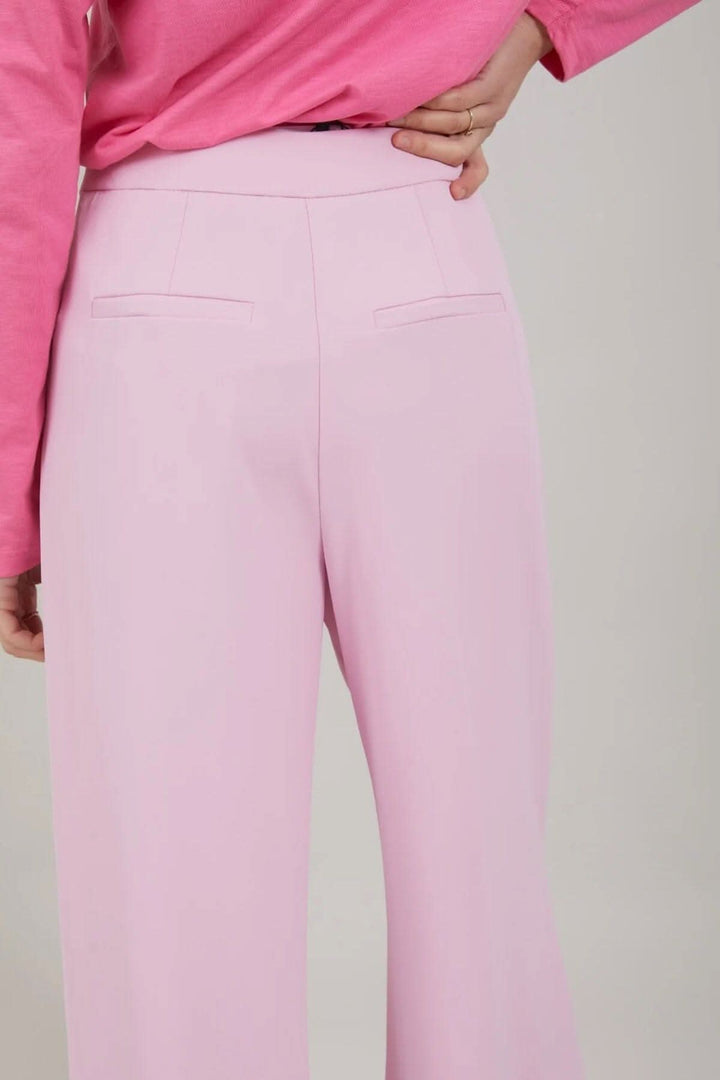 Vue arrière du pantalon Alba en rose, mettant en évidence les poches arrière et la coupe large.
