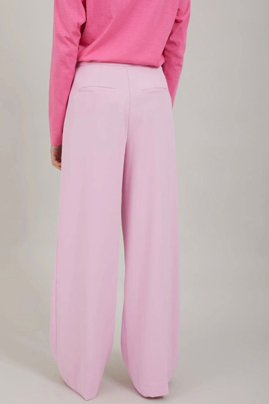 Pantalon Alba rose à jambes larges, vue arrière, avec deux poches et un haut rose.