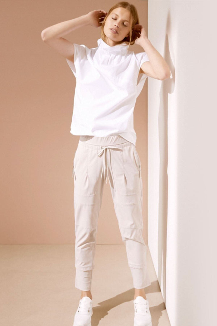 Modèle féminin portant un pantalon Candy beiger avec un top blanc, affichant un style décontracté et moderne.