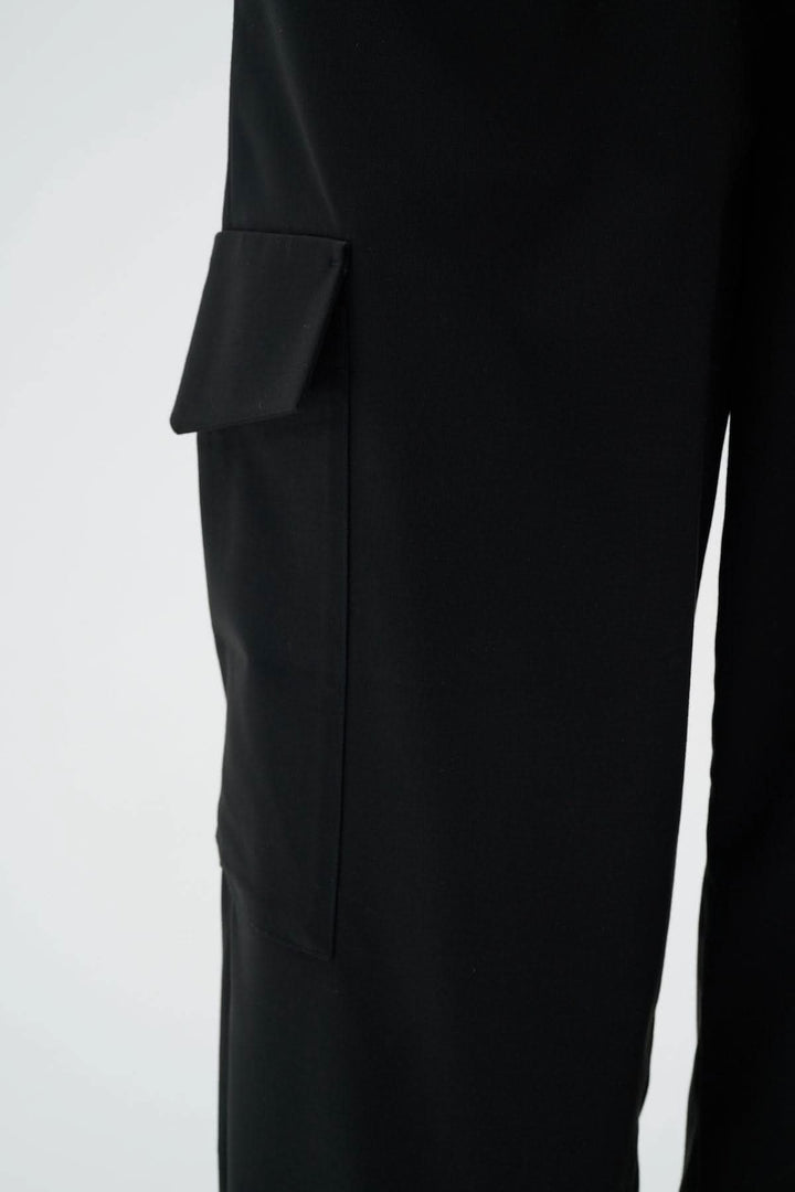 Pantalon cargo noir avec poche sur la jambe, taille élastique et coupe décontractée.