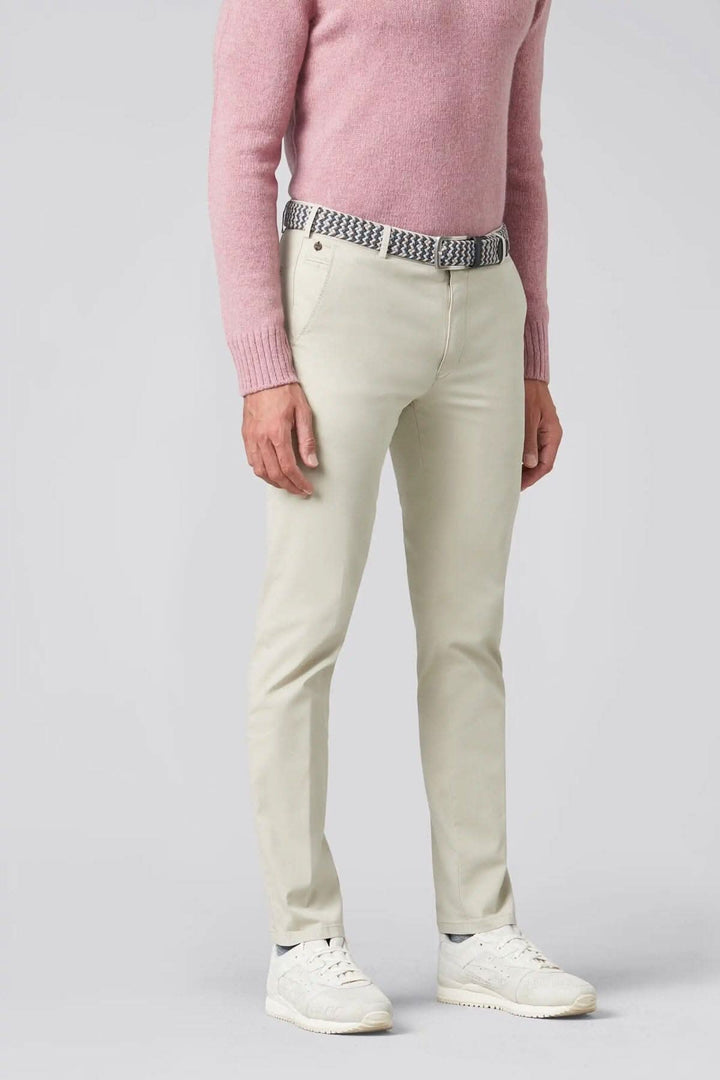 Pantalon chino respirant et thermorégulateur porté avec un pull rose, style moderne et confortable.