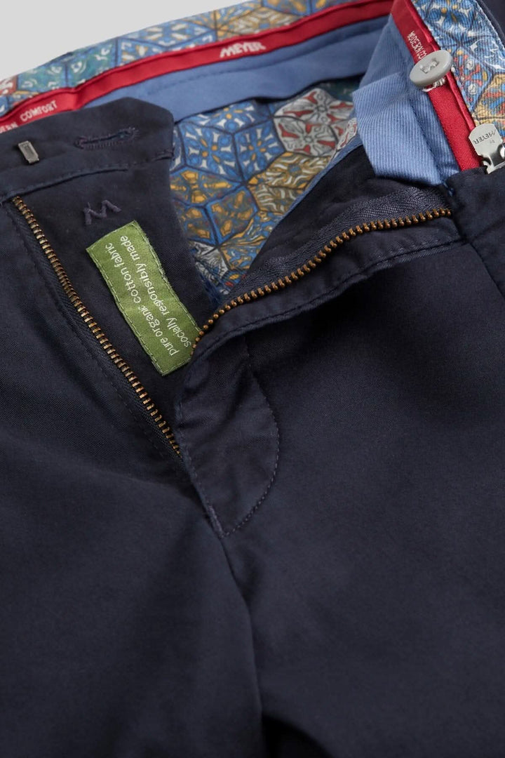 Détails d'un pantalon chino noir avec finition intérieure colorée et fermeture éclair.