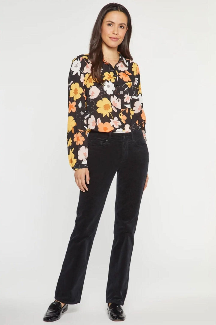 Femme portant le pantalon droit Marilyn en velours côtelé avec chemisier floral.