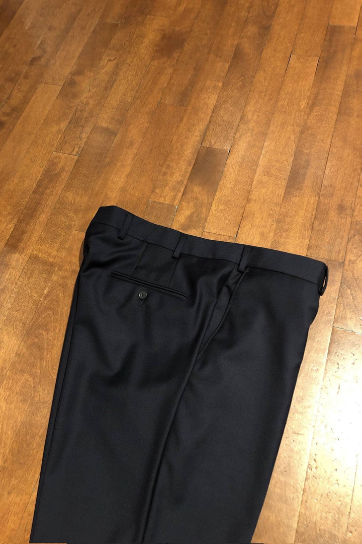 Pantalon en laine Samuelsohn noir, 100% laine, fabriqué au Canada, sur un sol en bois.