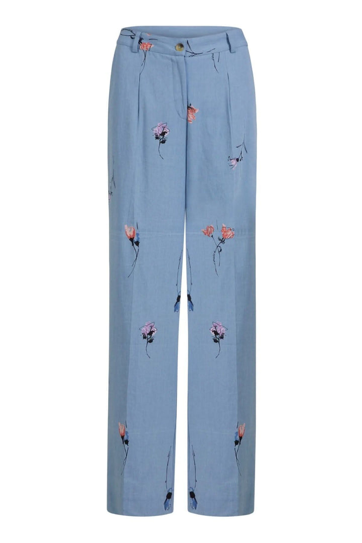 Pantalon large en denim bleu avec imprimé floral coloré, coupe baggy et poches avant et arrière.
