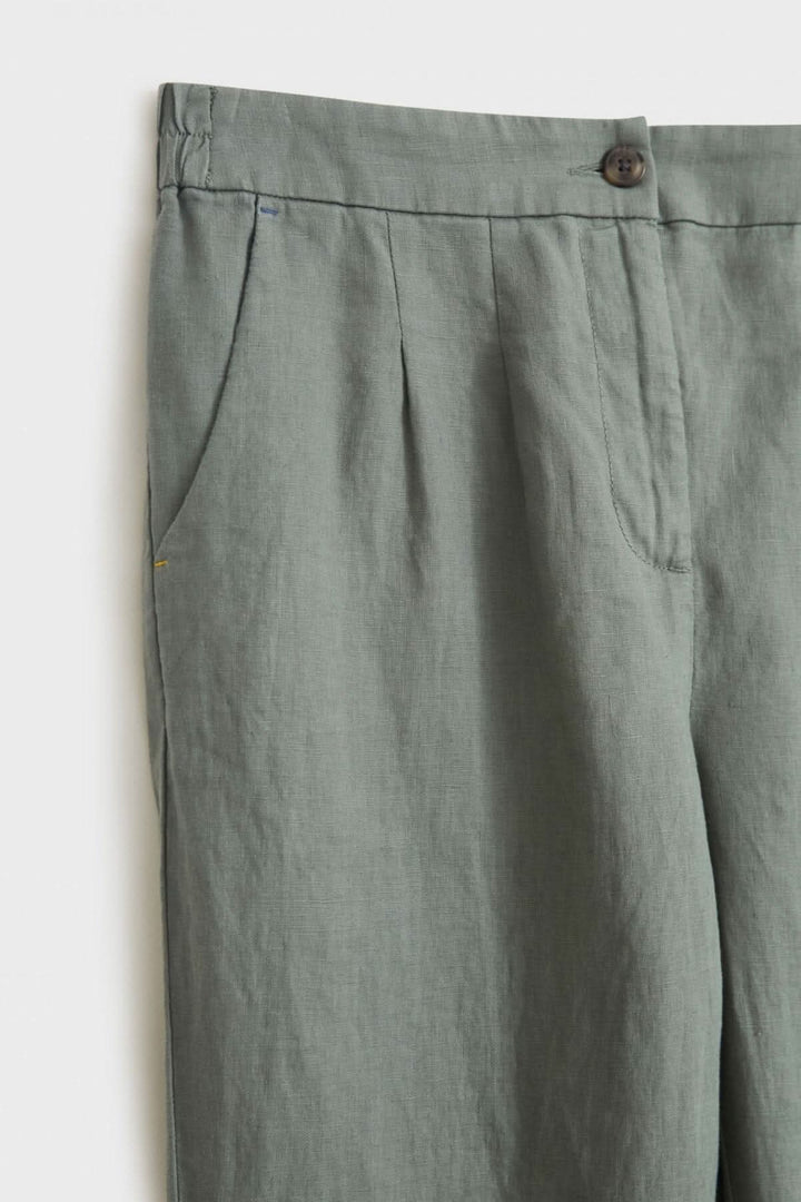 Pantalon Maddie en lin gris, détail du bouton et poches latérales diagonales.