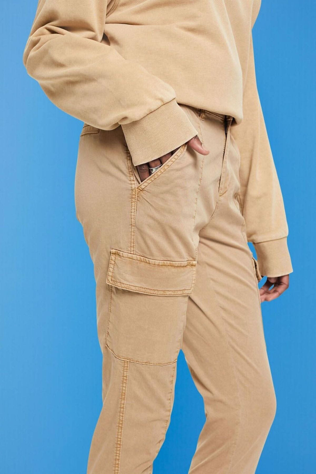 Pantalon en style cargo beige avec taille élastique et poches, parfait pour un look décontracté.