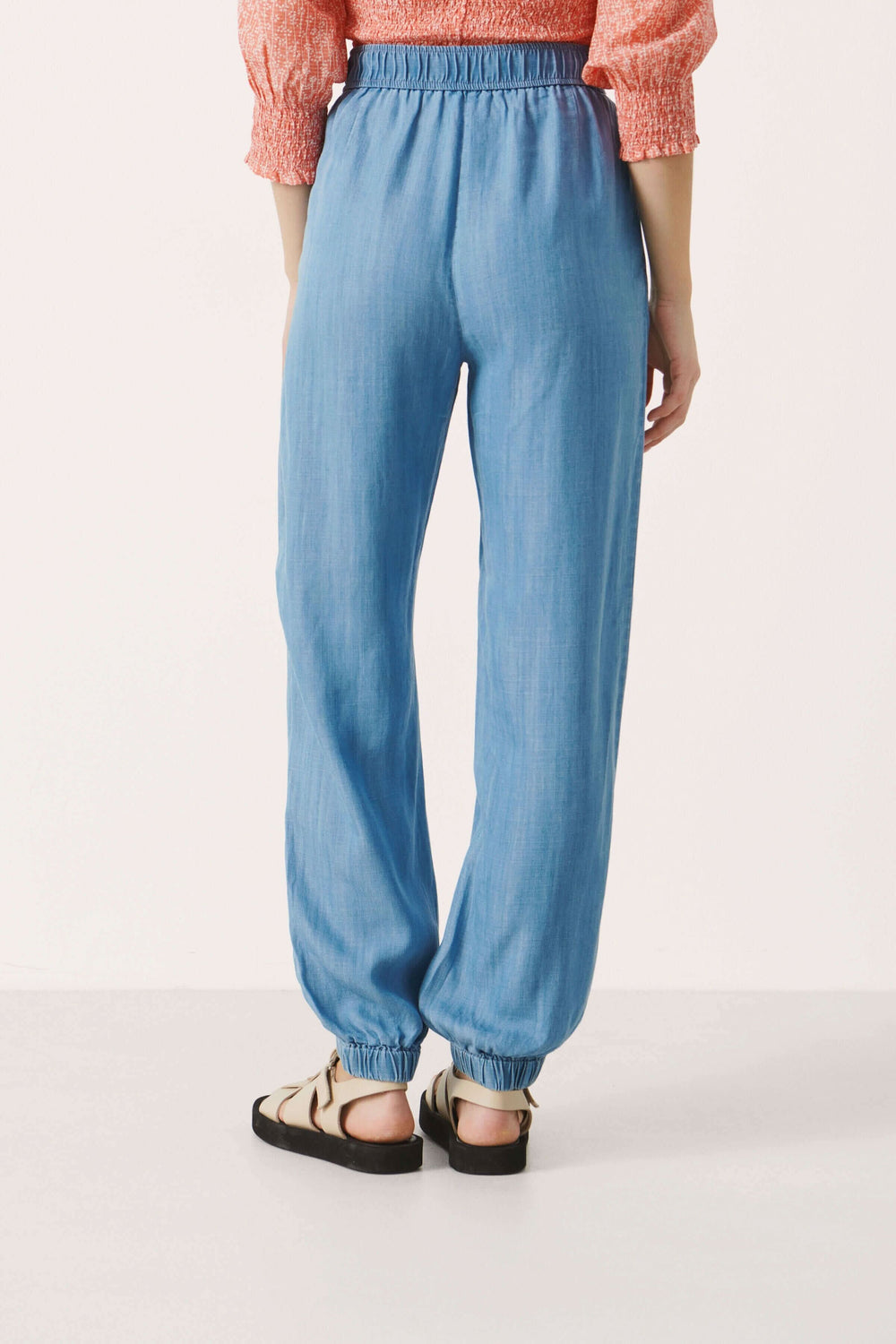 Pantalon Vilma en lyocell bleu, coupe décontractée avec élastique à la taille et aux chevilles, vu de dos.