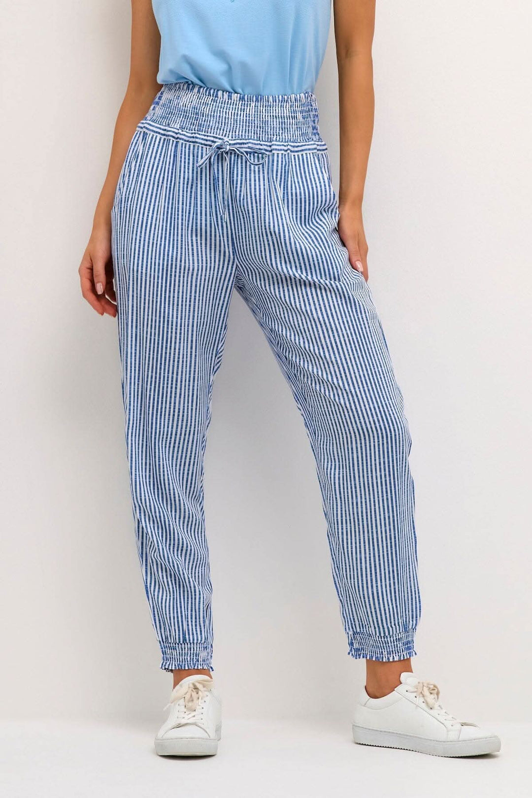Pantalon Willis à rayures bleues avec taille élastique et cordon de serrage, coupe ample et détails modernes.