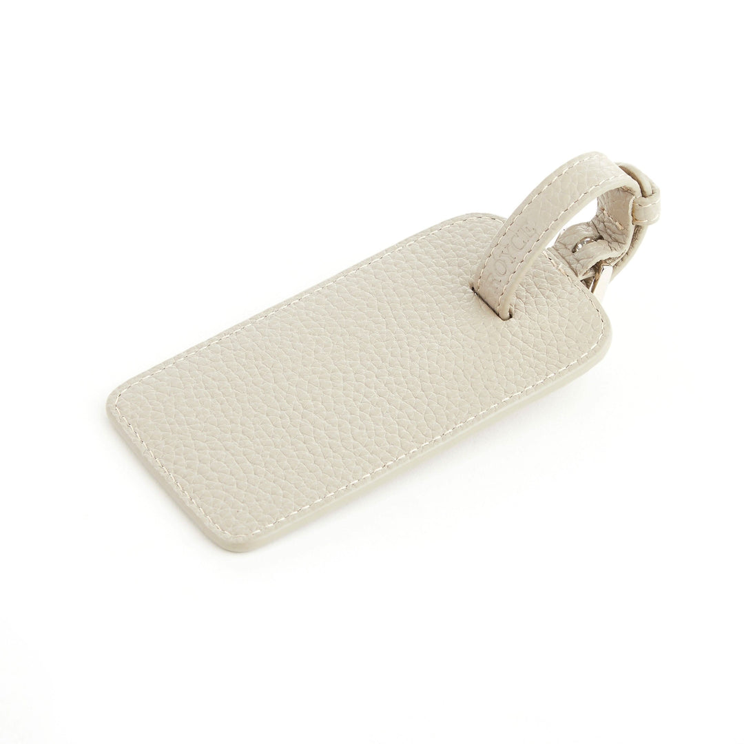 Étiquette à bagages en cuir beige, élégante et durable pour le voyage.