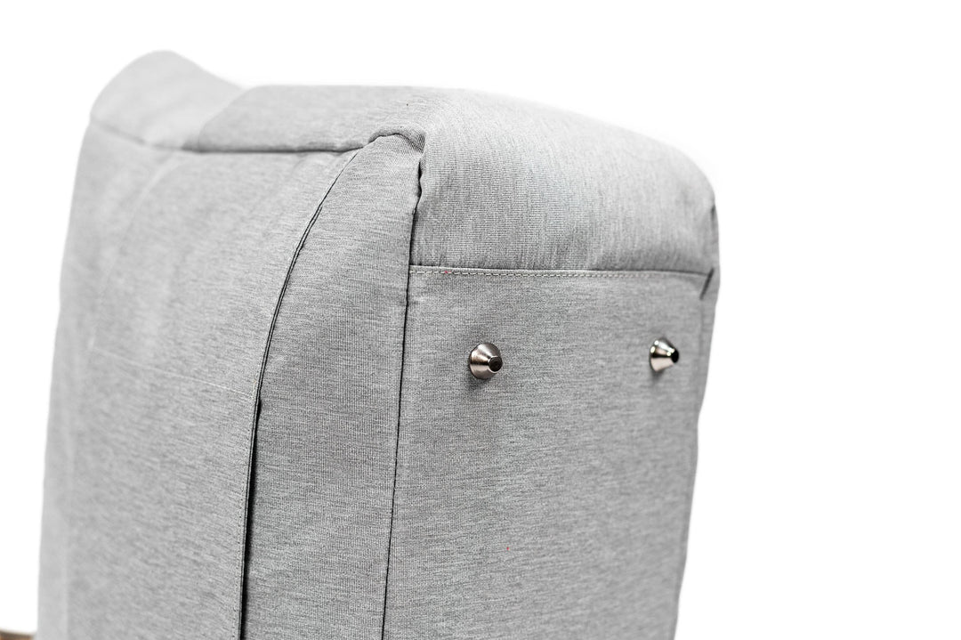 Close-up of a gray fabric bag's padded base, featuring metal feet accents for durability and stability.