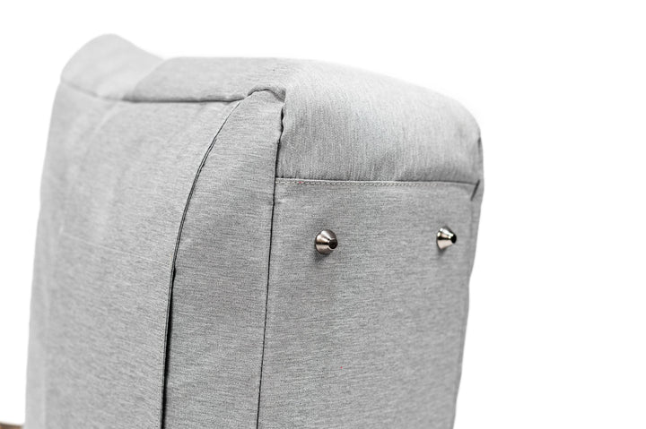 Close-up of a gray fabric bag's padded base, featuring metal feet accents for durability and stability.