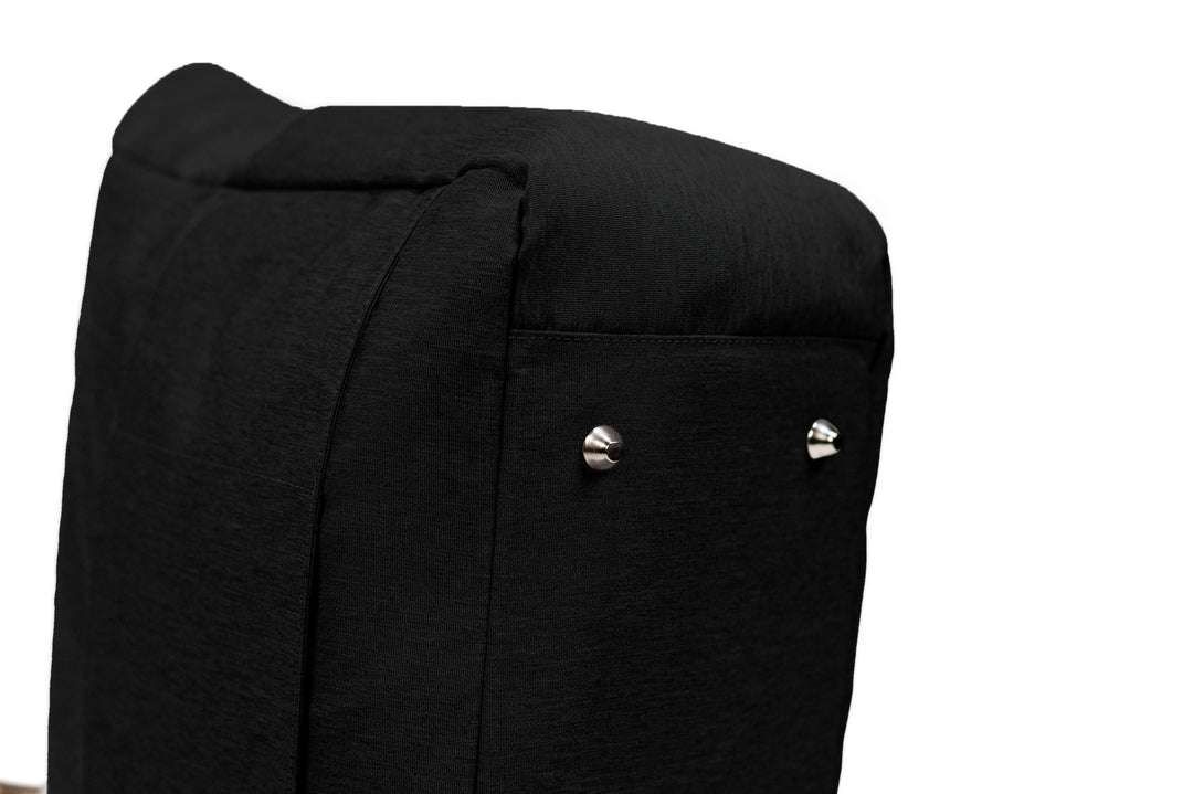 Close-up of a black upholstered chair back with metal accents showcasing elegant design details.