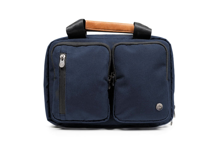 PKG Simcoe recycled essentials bag in navy with vegan leather handle and organized pockets for toiletries.