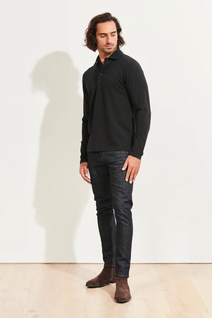 Homme portant un polo en coton stretch noir à manches longues avec un look décontracté.