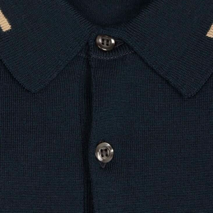 Détail du col et des boutons d'un polo en laine marine avec lignes beiges, élégant et confortable.