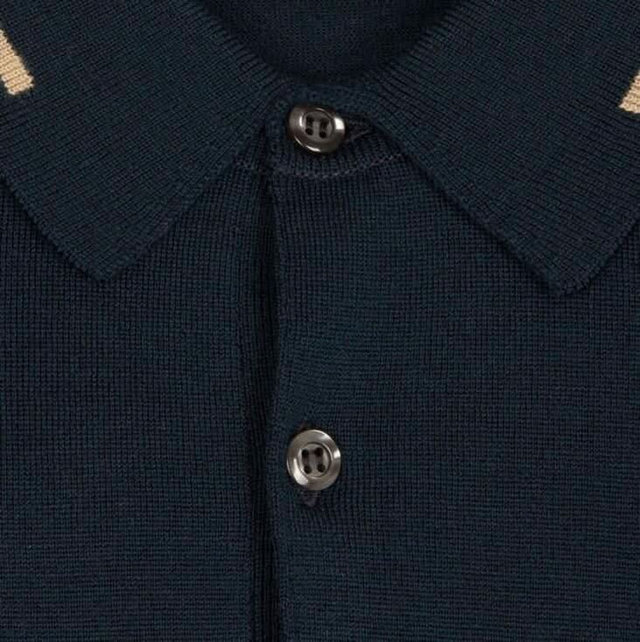 Détail du col et des boutons d'un polo en laine marine avec lignes beiges, élégant et confortable.