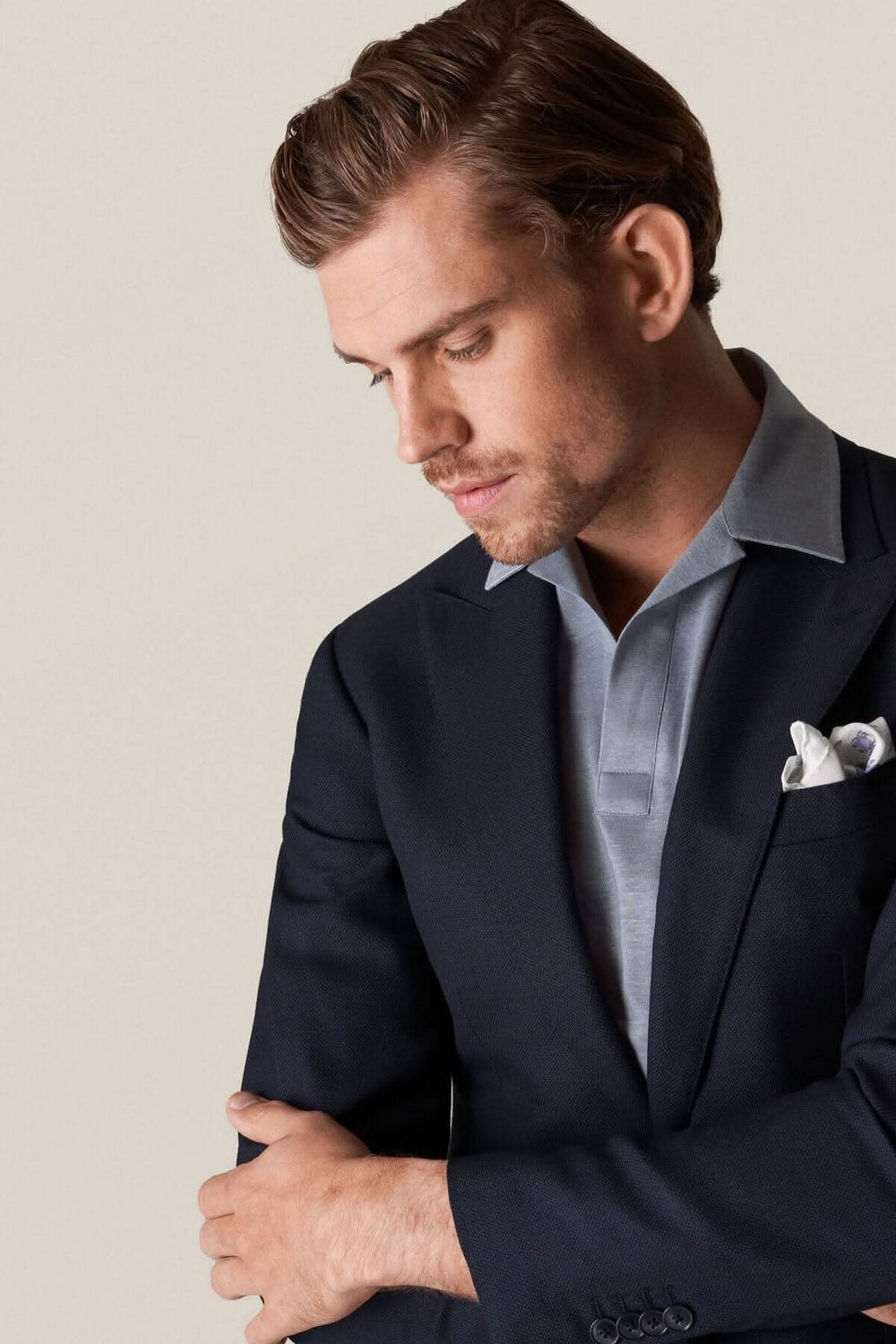 Homme portant un polo en lin et coton sous un blazer élégant, mettant en avant une allure raffinée.