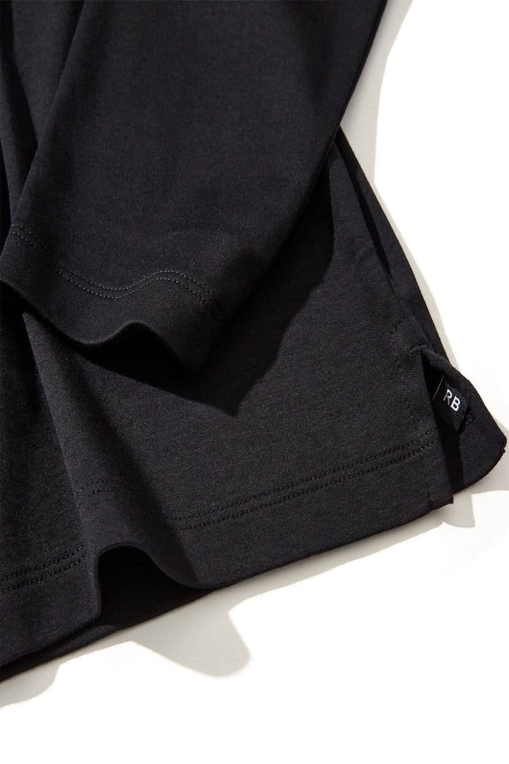 Polo Georgia en coton Pima noir avec col et patte de boutonnage en maille nid d'abeille, vue de près.