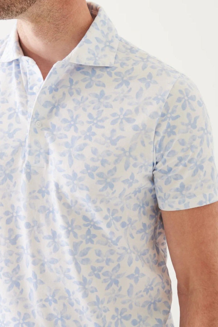 Polo en coton pima extensible avec motif floral bleu à manches courtes, parfait pour l&